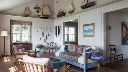 living room with blue wooden couch and with model boats on high shelf