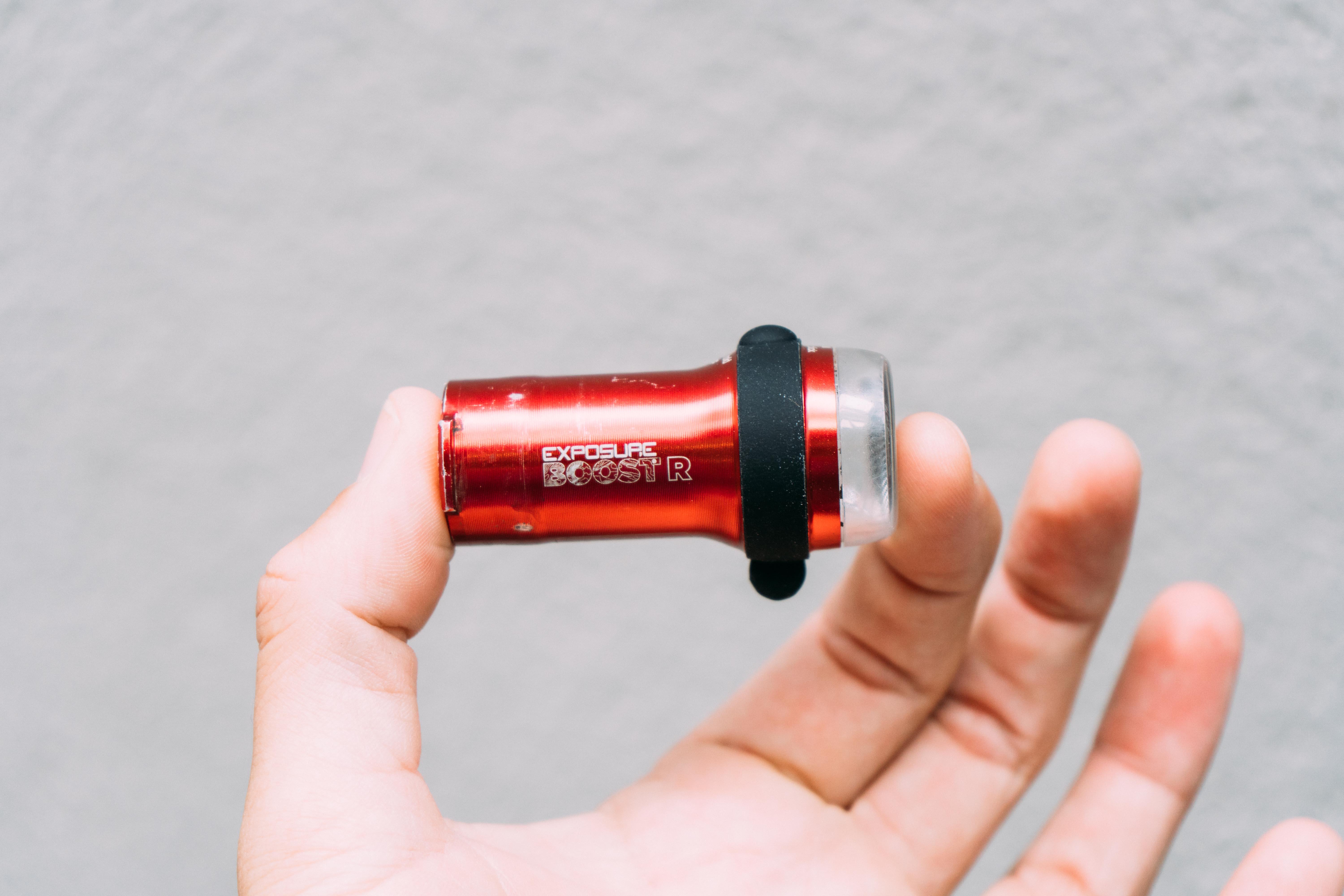 A red bike light held in a white hand