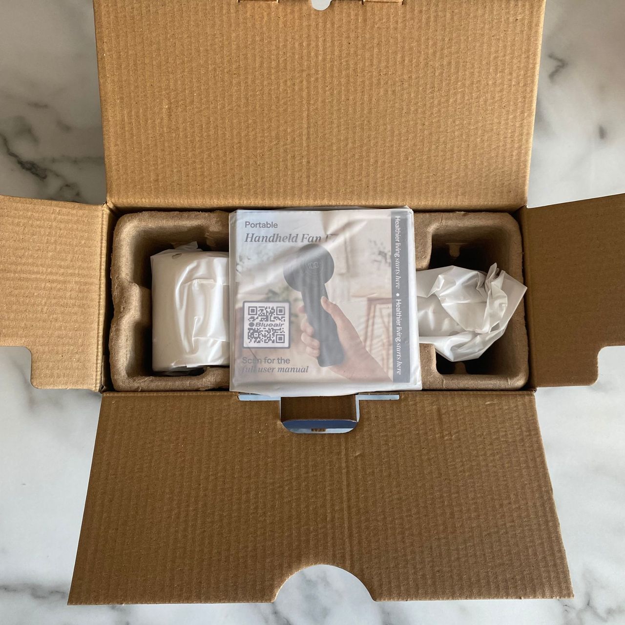 Open packaging of the Blueair AlwaysCool Portable Handheld Fan