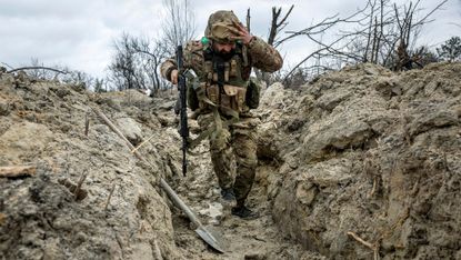 A Ukrainian medic runs through a trench outside Bakhmut 