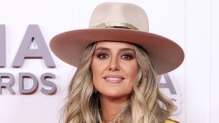 Headshot of country singer Lainey Wilson, sporting blonde tousled hair and a western-style hat, ahead of the annual Country Music Association Awards 2023.