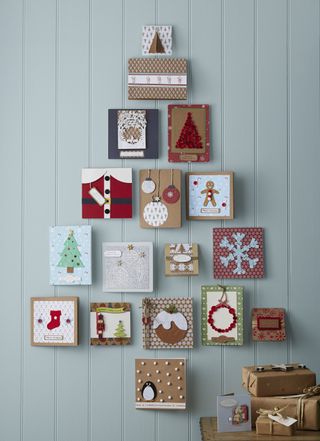 A Christmas card display organized in tree shape with duck egg blue shiplap wall decor