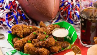 Buffalo wings with dip next to football