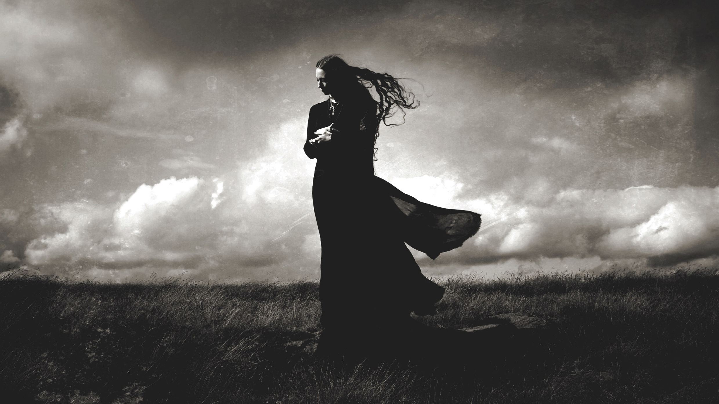 Darkher black and white image on a grassy hill