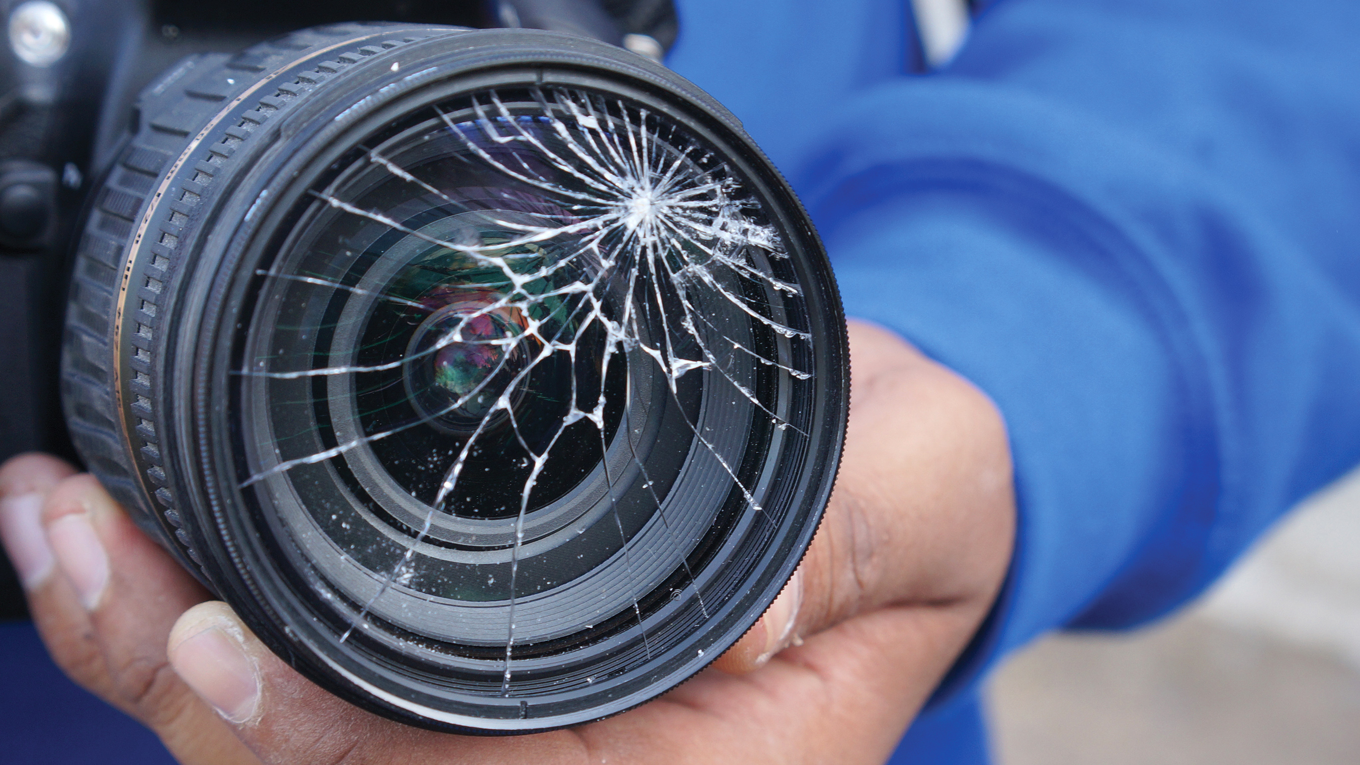 Man holding broken DSLR camera lens; Shutterstock ID 286091423