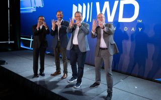Ambrish Srivastava, Ahmed Shihab, Irving Tan, and Kris Sennesael performing a "WD" hand gesture at Innovation Day 2026.