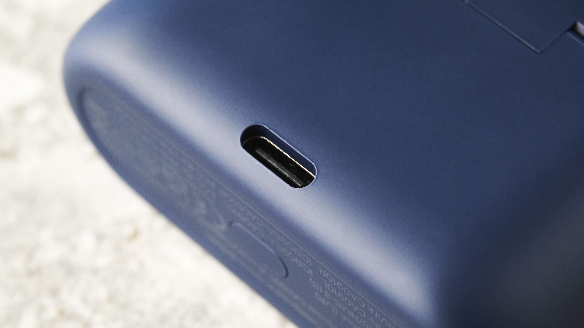 the cambridge audio a100 se earbuds on a blue tom's guide background with a stone-coloured table underneath
