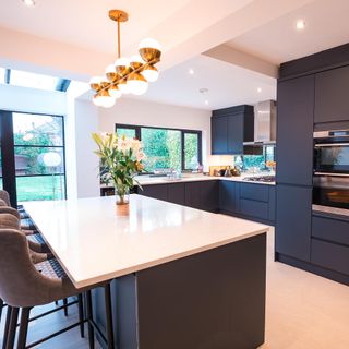 kitchen with grey cabinet white table and potted plant