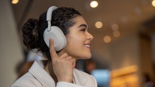 Eine Frau nutzt die Sony WH-1000XM5 zum Musik hören