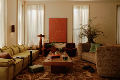 a pink dining room with dark red chairs