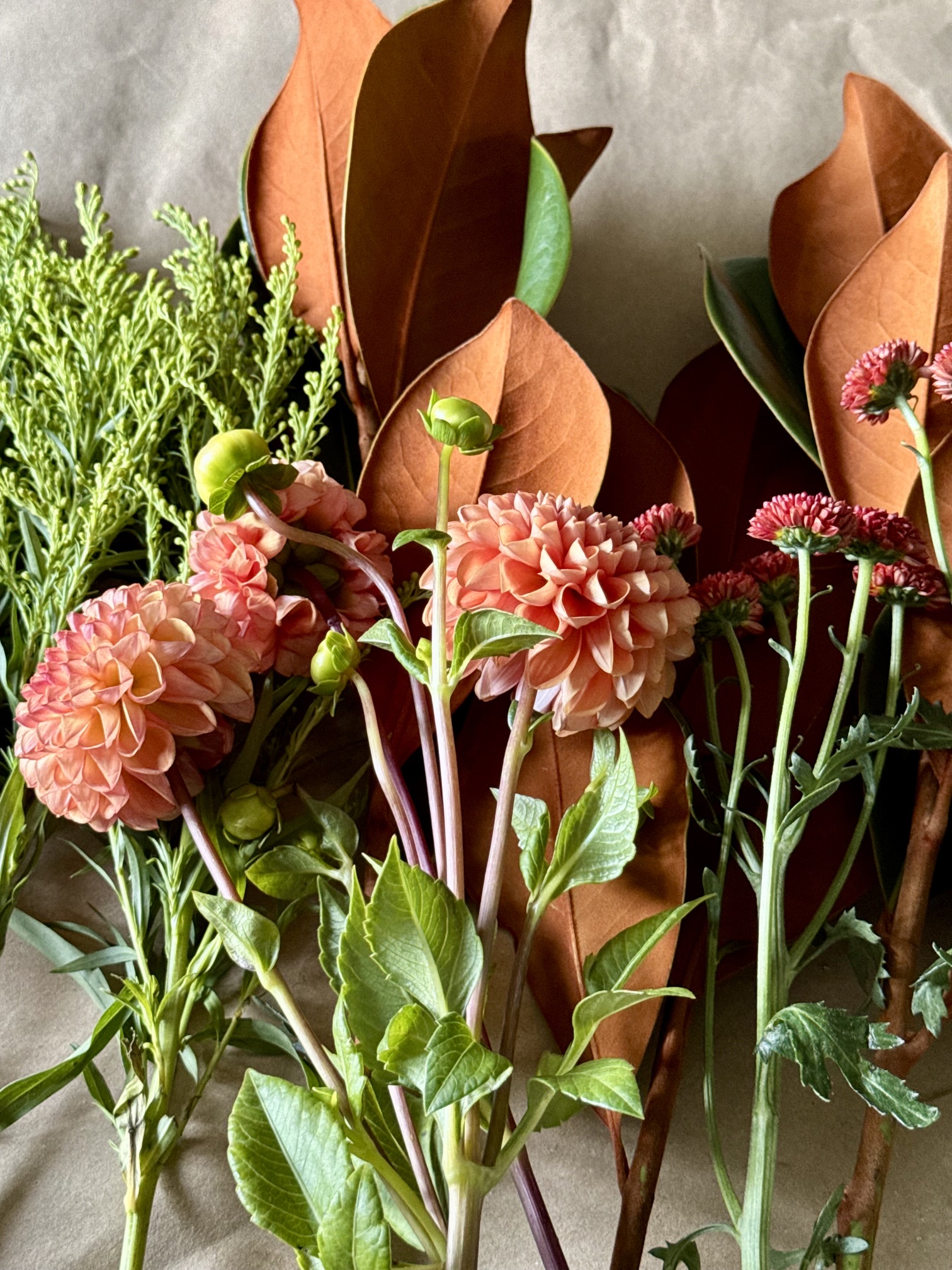 fall mums and magnolia on kraft paper on a table