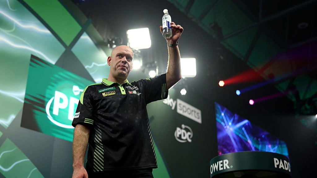 Michael van Gerwen raises his bottle of water to acknowledge the crowd during the 2026 PDC World Darts Championship