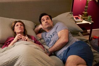 A woman (Sharon Horgan as Sharon Morris) lies in bed under the covers as a man (Rob Delaney as Rob Morris) lies with his head resting on his hand, in 'Catastrophe.'