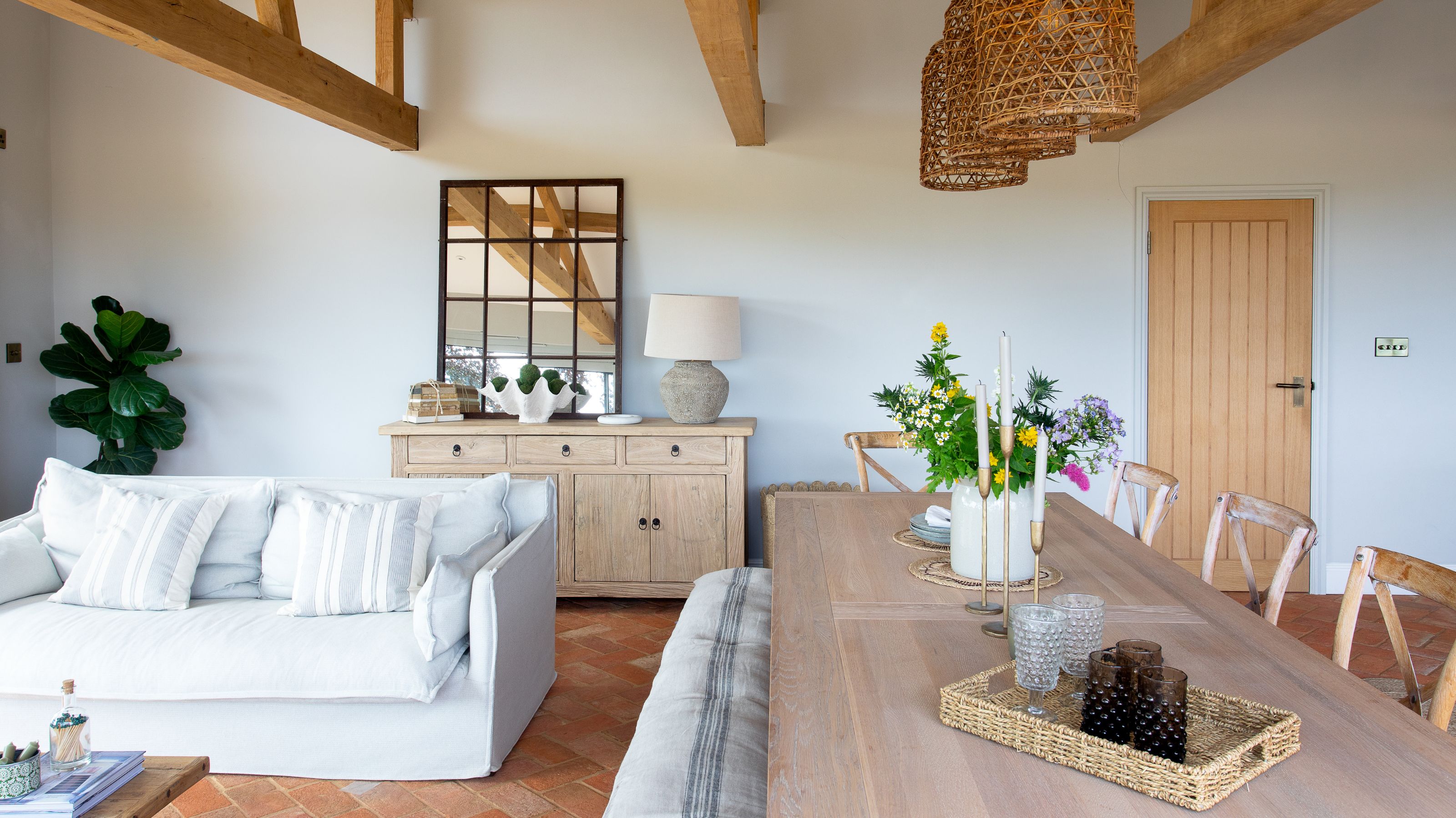 Open plan dining and living room, with a wooden dining room table and a white sofa
