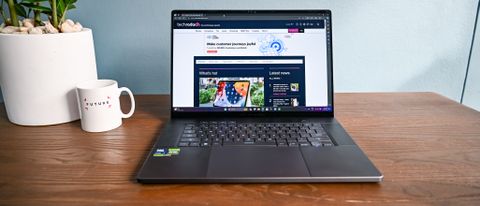 Asus Zephyrus G16 on table beside a mug and potted plant