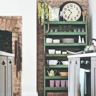 A kitchen with a vintage open bookshelf used to display tableware