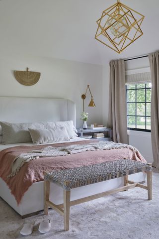bedroom with pink bedding white upholstered bed metal light and steel framed windows
