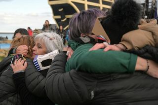 a close up photograph of people hugging.