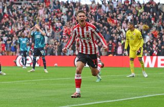 Chris Rigg of Sunderland back heals the opening goal then celebrates with his team mates during the Sky Bet Championship match between Sunderland AFC and Middlesbrough FC at Stadium of Light on September 21, 2024 in Sunderland, England.