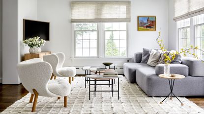 living room with white walls, two boucle chairs and grey sofa