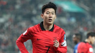 Son Heung-min, wearing a red and black South Korea soccer shirt, warms up for the AFC Asian Cup in Qatar.