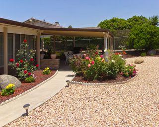 gravel garden with flowerbed and covered patio