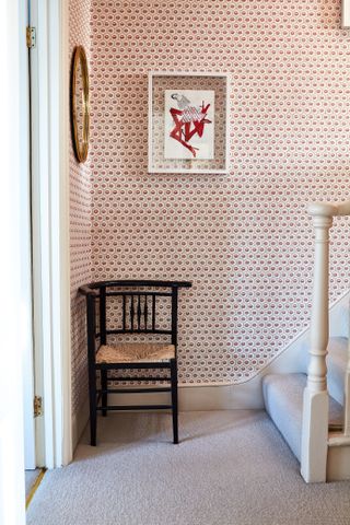 patterned wallpaper in hallway in Victorian London home with antique chair