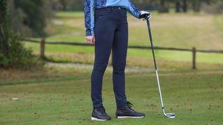 A golfer wears the Ping Verity Pants