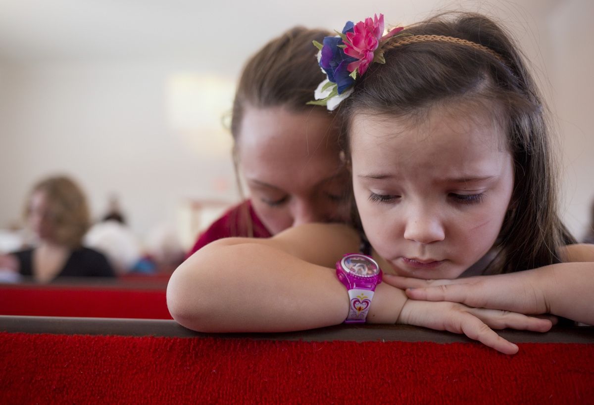 The prescription drug Narcan saved Shannon Long from an opioid overdose. Here, she kneels with her daughter Hope at Woodstock Seventh Day Adventist church on Feb. 4, 2017.