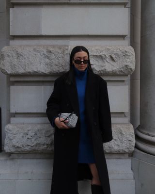 Winter basics UK: @byteganfrances wears a knitted dress with a black coat and knee-high boots