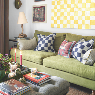 green sofa with geormetric cushions and hanging print above it.