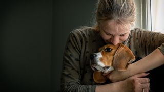 Stressed woman cuddling dog