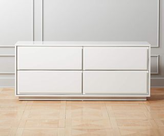 White CB2 dresser against a gray wall.
