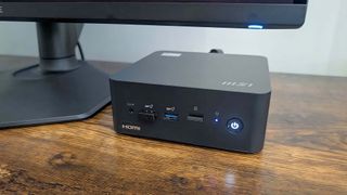 MSI Cubi NUC 13MQ set up on a desk under a monitor.