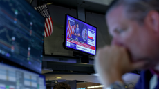 A television station broadcasts Kevin Warsh, chairman of the US Federal Reserve, speaking after a Federal Open Market Committee meeting as a trader works on the floor of the New York Stock Exchange.