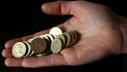 A person holds one pound coins
