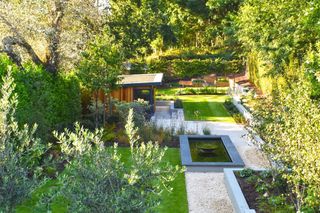 Yard from above, areas of neat lawn, a water feature and outdoor wooden sunroom