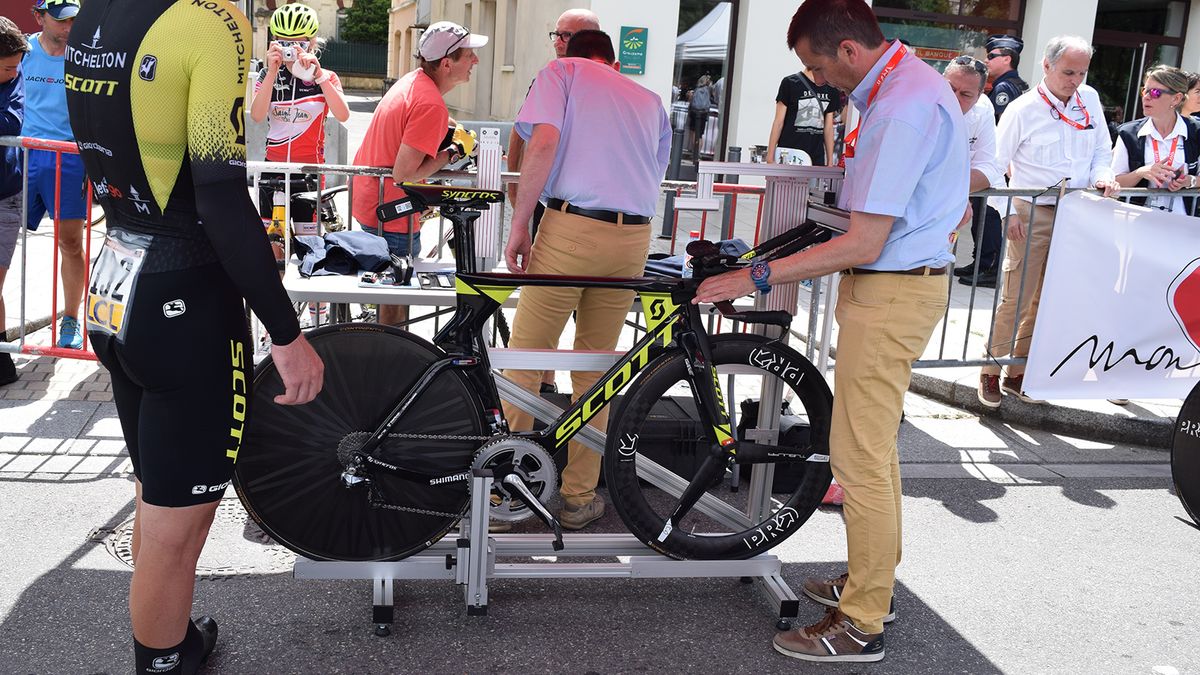 UCI representatives measure each bike with a jig to ensure they meet the regulations before each rider is allowed to set off