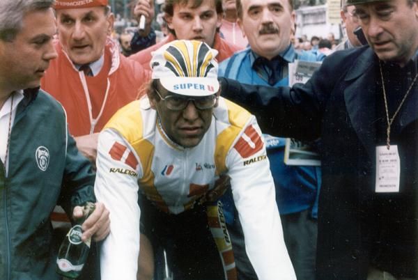 A grimy Laurent Fignon heads to the podium after winning the 1989 Milan-San Remo.