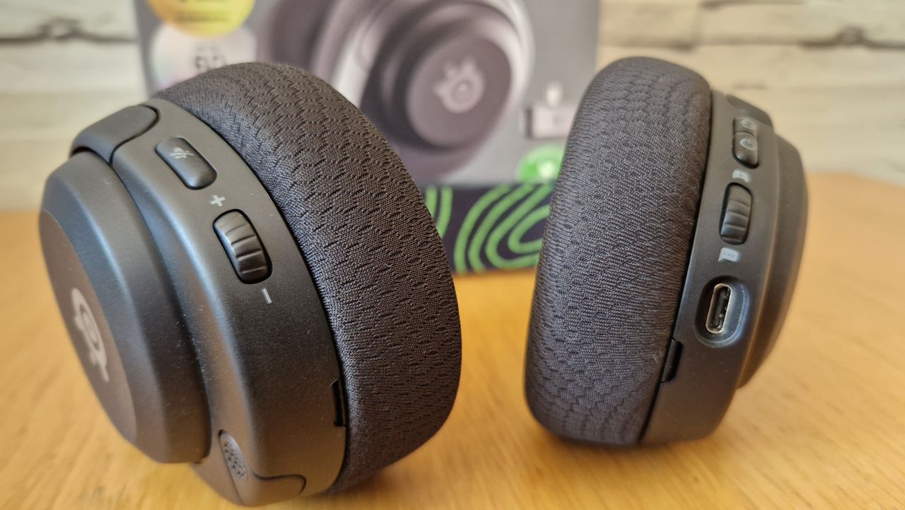 The SteelSeries Arctis 5X gaming headset on a wooden surface with the box in the background