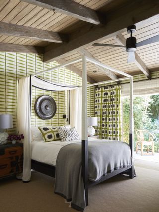 tropical design bedroom with large glass doors overlooking nature
