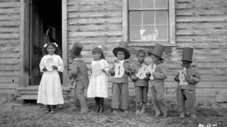 First Nations children hold letters that spell "Goodbye" at Fort Simpson Indian Residential School in Canada's Northwest Territories, in 1922.