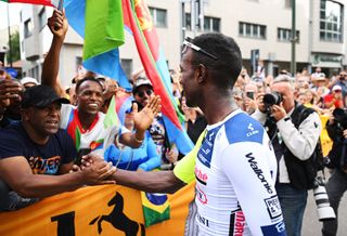 Girmay celebrates with a cluster of Eritrean fans after sprinting to glory on stage 3