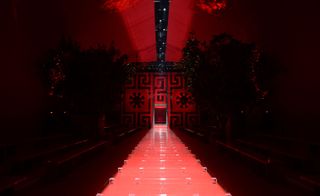 Dontella Versace's models arrived through a commanding red and black backdrop derived from the outer edges of the house's Medusa logo