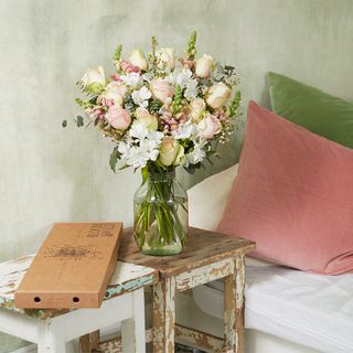 blush tone flower with snapdragon flower table with cushions and white walls