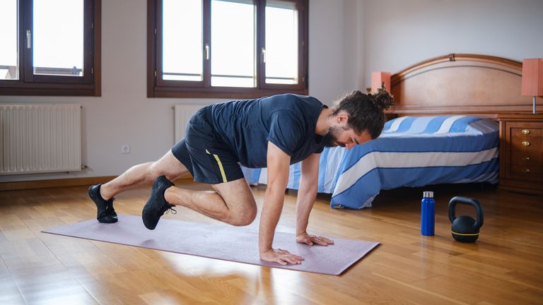 Man performing mountain climbers at home