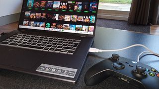 Acer Chromebook 516 GE review; a gaming laptop on a black coffee table with a controller