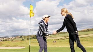 Women golfers shaking hands