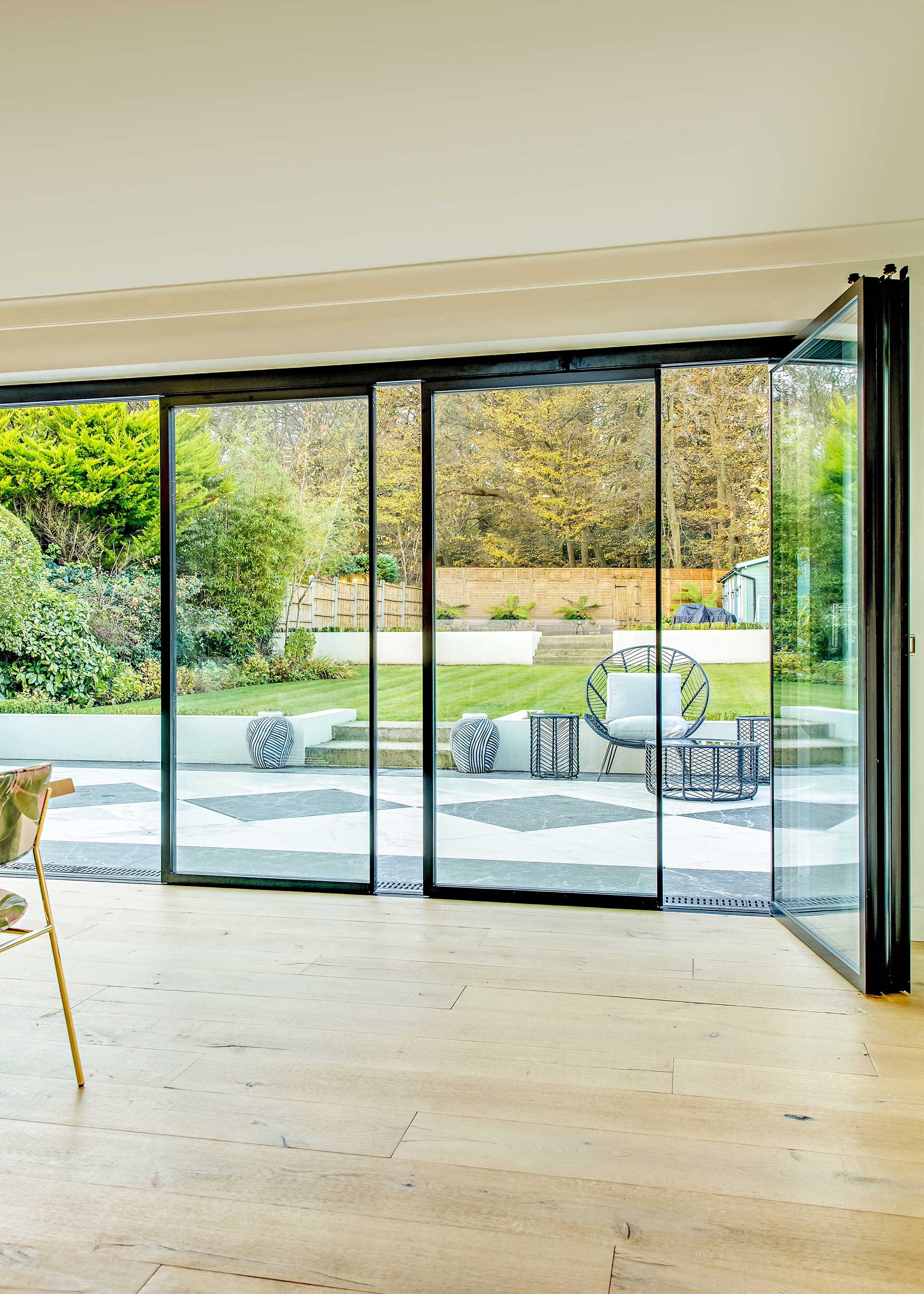 slimline aluminium slide and turn doors leading to black and white paved patio