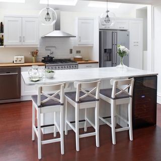 kitchen with white dining table and white chairs